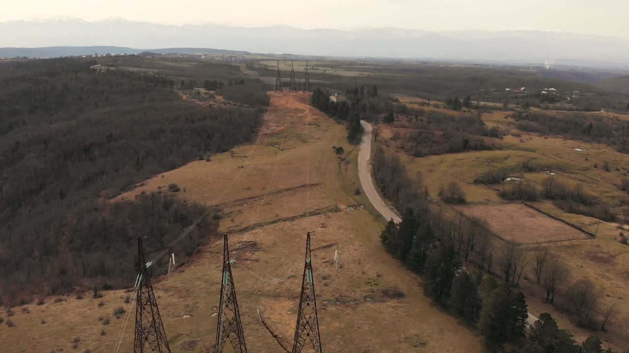 Aerial footage of electric high voltage power transmission towers on a field 3