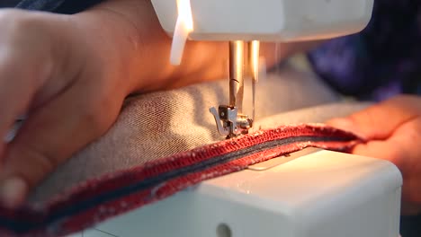 costurera cosiendo material de mezclilla en la máquina, haciendo jeans, arreglando