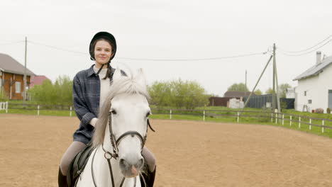 pretty woman smiling and riding a beautiful white horse