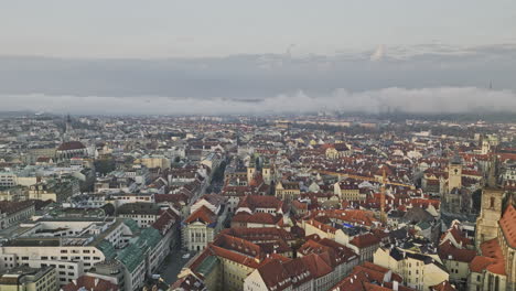 prague czechia aerial v134 cinematic drone flyover historic old town district capturing morning cityscape with sunrise misty clouds covering the city - shot with mavic 3 cine - november 2022