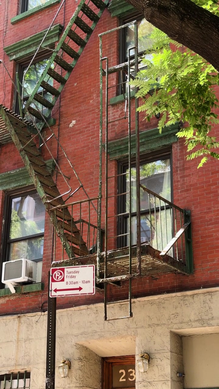 Escalera de incendios exterior bajando por un edificio de apartamentos de ladrillo en la zona urbana de Nueva York