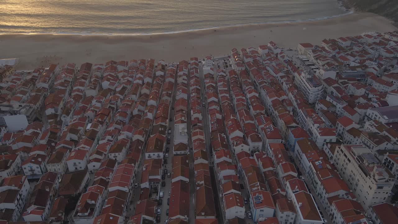 Filmato aereo con drone della città di Nazaré sulla costa del Portogallo, ripreso durante l'ora d'oro del tramonto in 4K