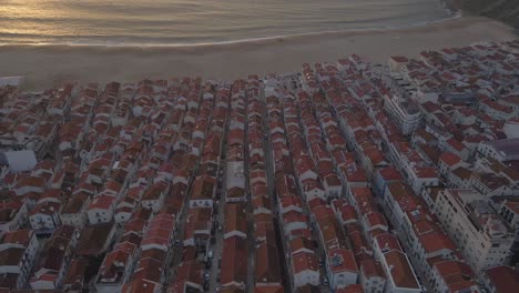 imágenes de drones de la ciudad de nazare en la costa de portugal filmadas durante la hora dorada del atardecer 4k