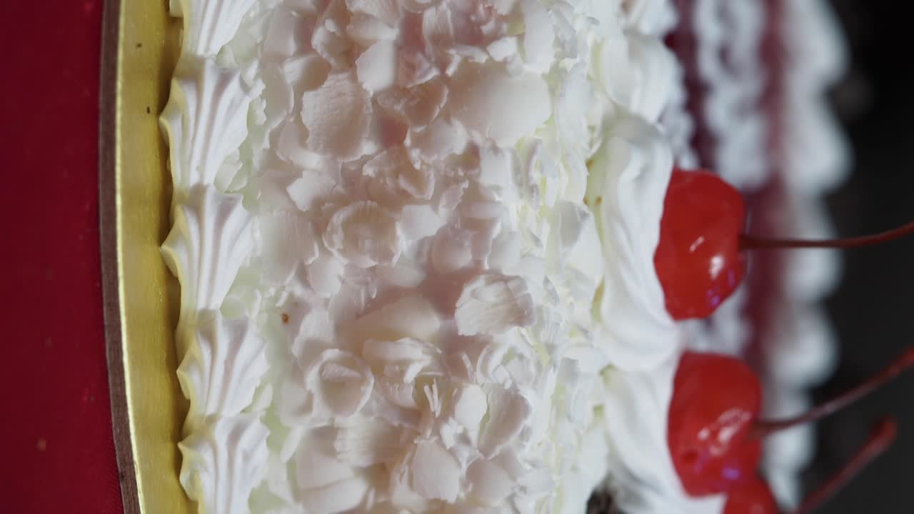 Closeup of a Frosted Cake with Cherries and Coconut