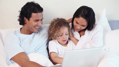 Boy-using-a-laptop-while-sitting-in-a-bed