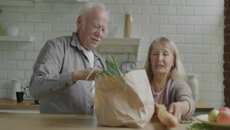 senior couple unpacking groceries at home