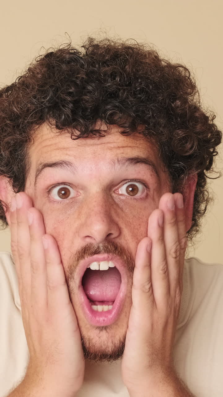 Primo piano di un uomo che reagisce con shock e sorpresa, poi sorride