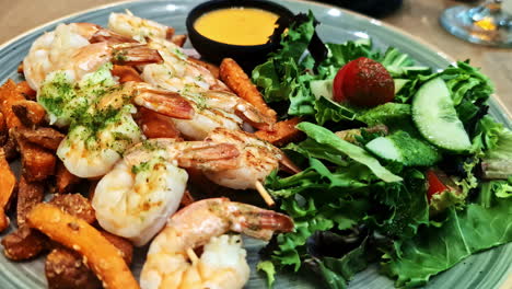 skewered shrimp served with sweet potato fries, salad, and mustard sauce dip