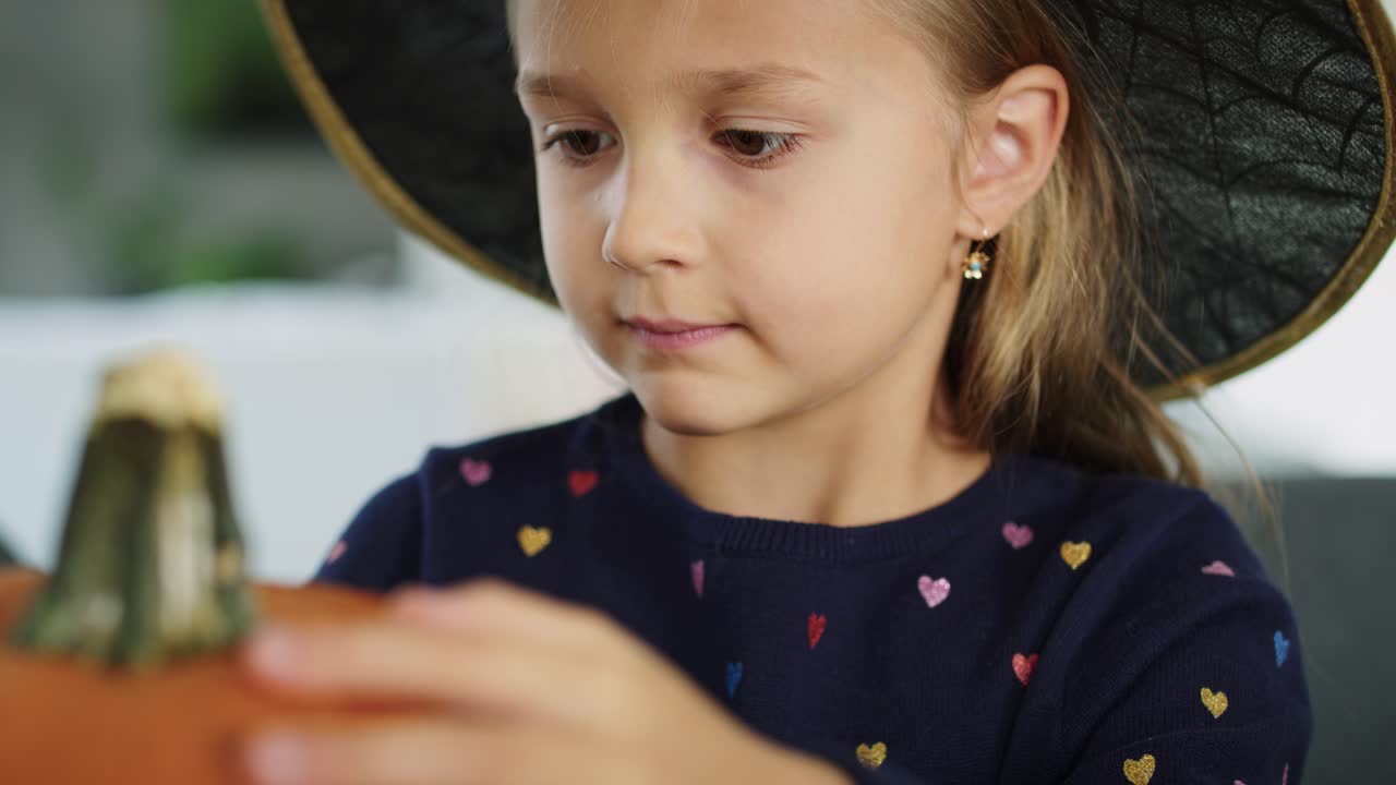 할로윈 호박에 정말 무서운 얼굴을 그리려고 하는 소녀