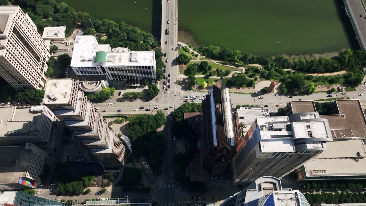Aerial view of a vibrant city skyline featuring skyscrapers, a river, and a busy street scene