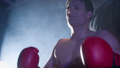 fuerte boxeador aplaudiendo sus manos en guantes de boxeo
