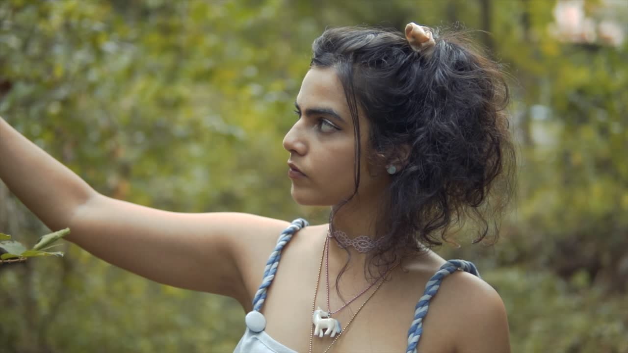 una joven afuera en un jardín admirando las plantas en una mañana fresca