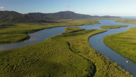 Beautiful-river-rainforest-landscape,-boat-moving-on-river-in-jungle,-aerial