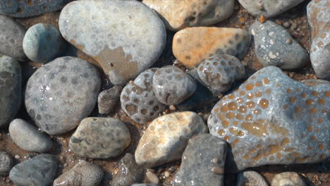 Cinematic-shoreline-Lake-Michigan-Petosky-Stone-rocky-beachside-peaceful-dramatic-state-park-Harbor-Springs-Mackinaw-Island-Up-North-summer-daytime-bright-afternoon-calm-peaceful-slow-pan-upward