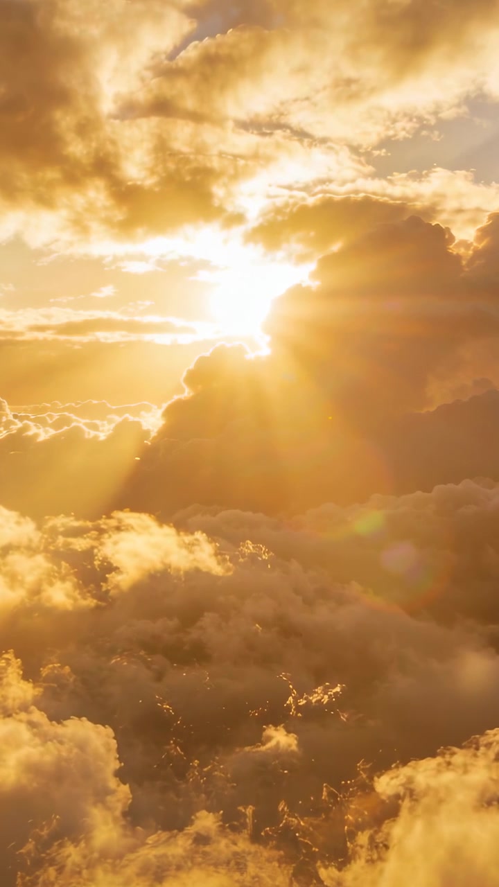 Vertical video: Shifting cloud edges revealing sun at dusk while clouds casting rays and flare