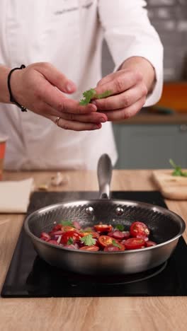 chef preparando un plato con tomates, cebollas y cilantro