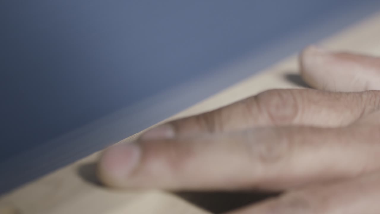 Close-up of sanding wood with fingers