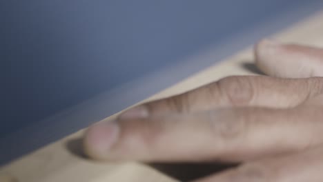 close-up of sanding wood with fingers