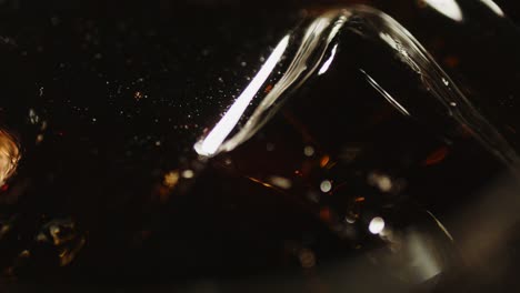 Makro-Eines-Eiswürfels,-Der-In-Einem-Glas-Cola-Schwimmt