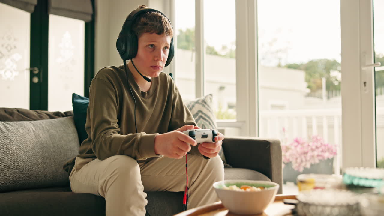 Teenager playing video games at home