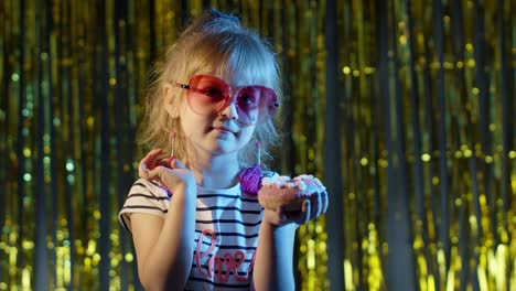 niña joven elegante y a la moda en una fiesta de discoteca en un club cyberpunk comiendo una gran barra de chocolate dulce