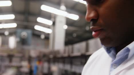 worker maintaining record on clipboard in factory
