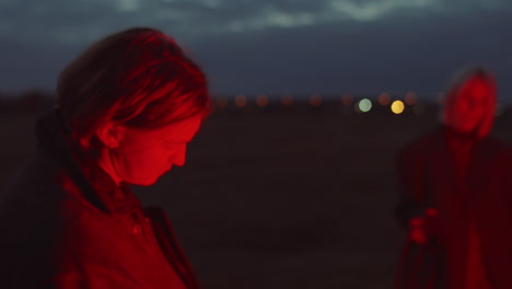 young couple dancing in red light outdoors