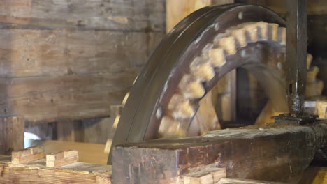 close up shot of rotating cogwheels of old wooden water mill in nature