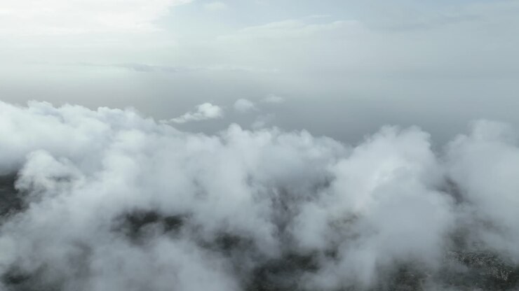 Drone footage flying above the clouds and the sea