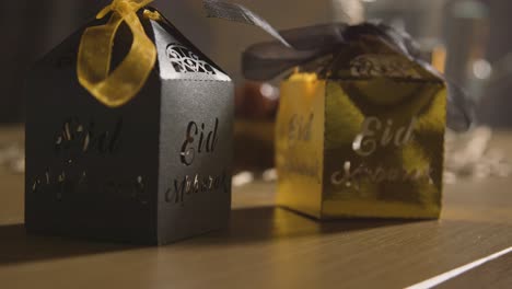 eid 4를 축하하는 이슬람 가정의 테이블 위에 선물 상자를 닫습니다