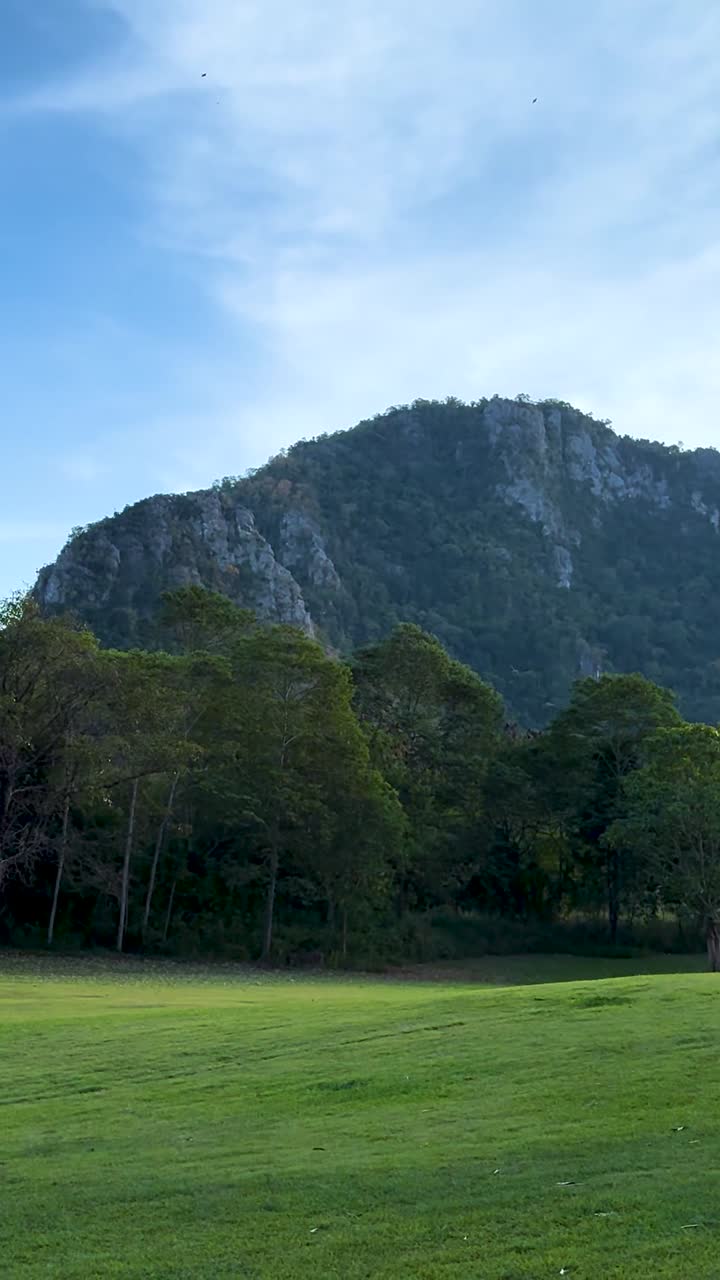 ภูมิทัศน์สีเขียวชอุ่มที่มีฉากหลังเป็นภูเขา