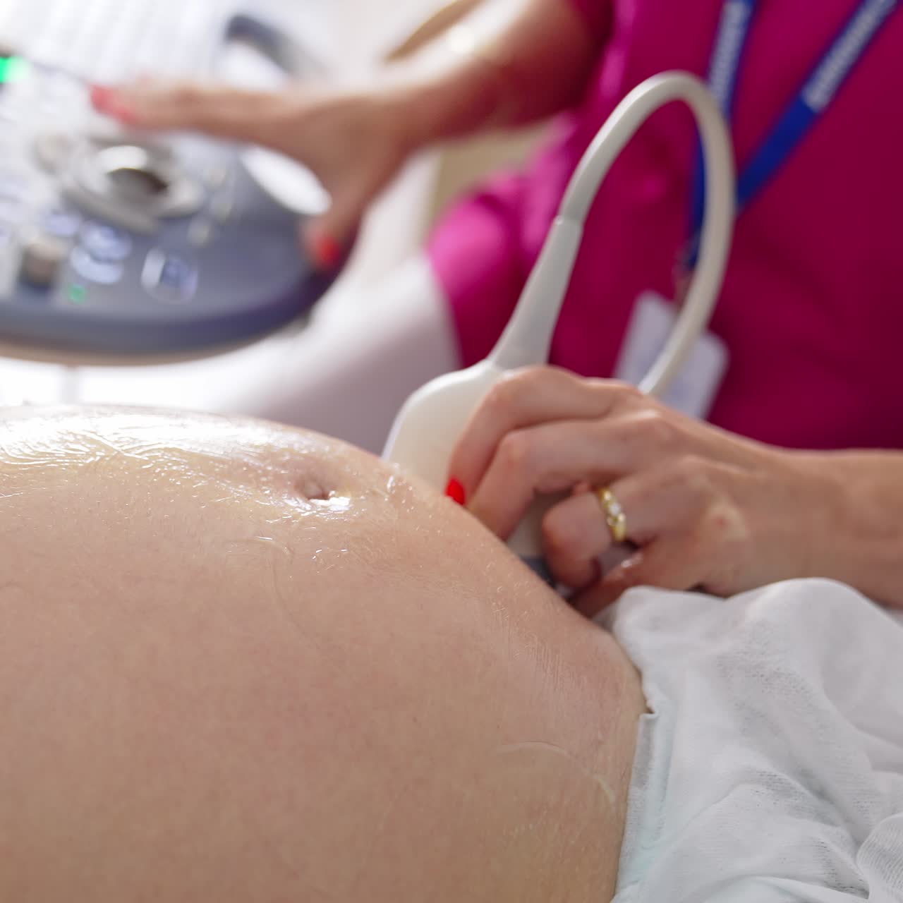 Pancia di una donna incinta durante l'ecografia. Il medico usa l'attrezzatura per ecografia mentre controlla la donna incinta. Primo piano.