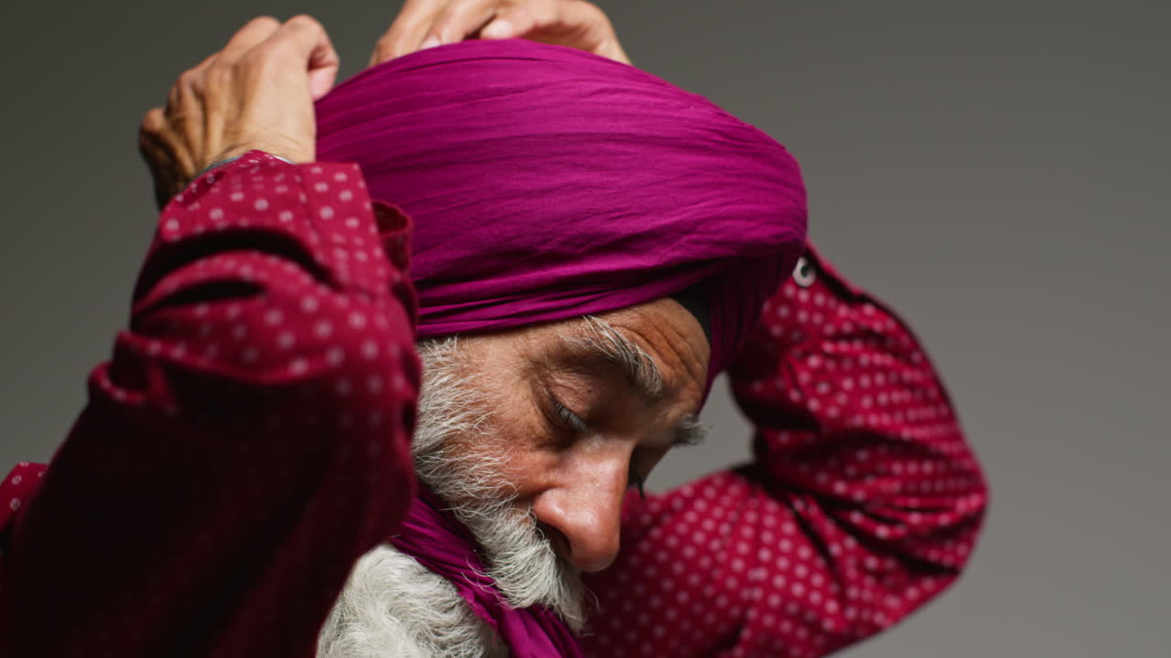 A Sikh man wearing a pink turban