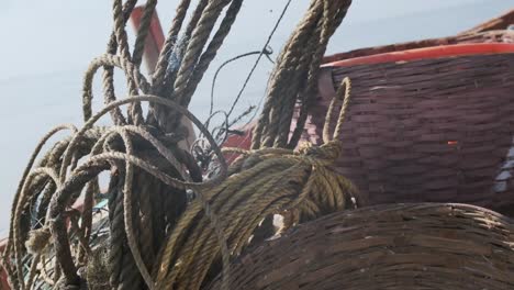 indian fishermen picking up a rope from side of boat slow motion