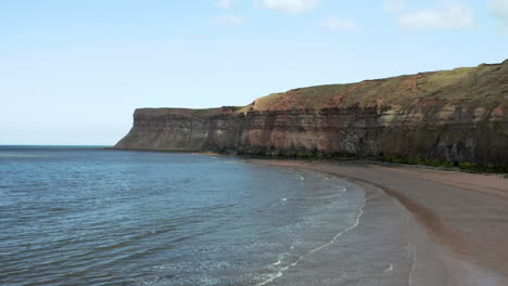 Aerial-Dolly-Shot-of-Yorkshire-Beach-and-Headland-on-Sunny-Spring-Day