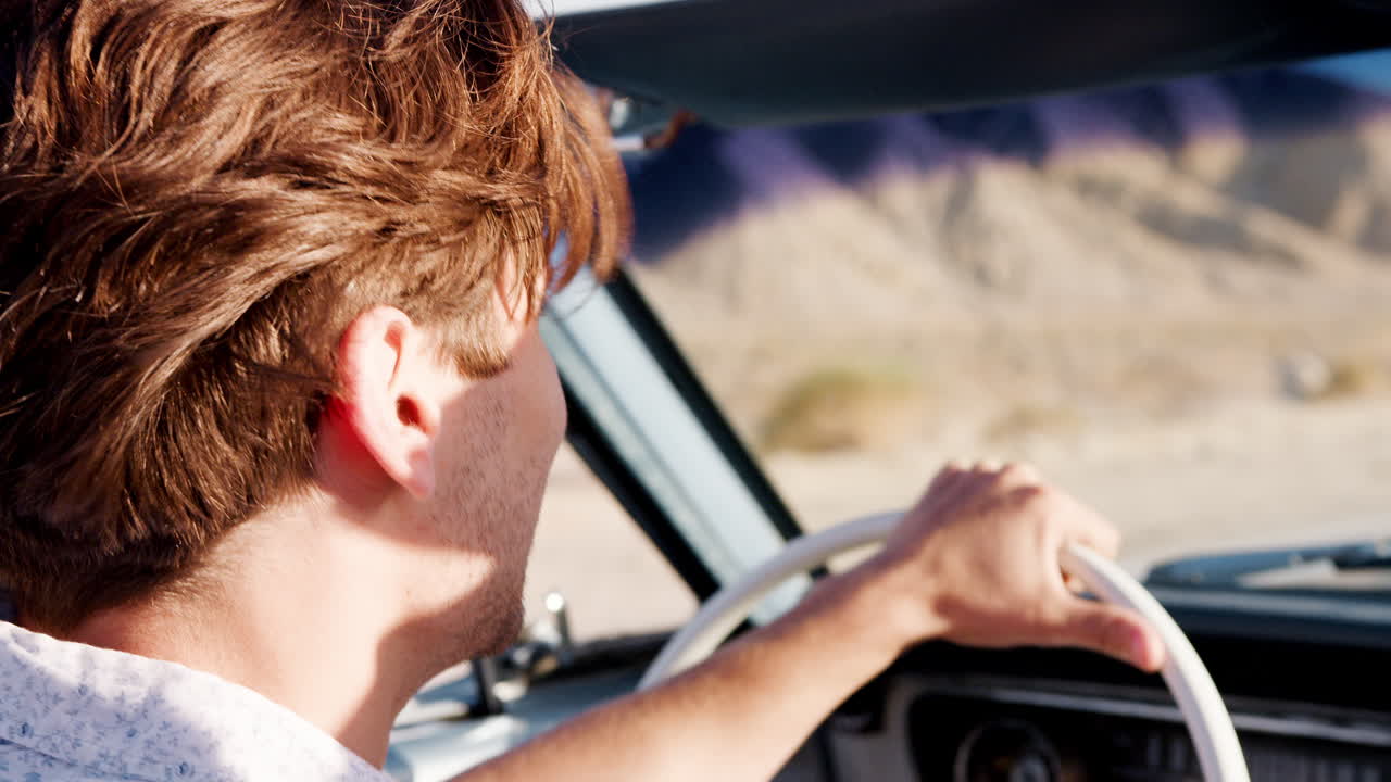 젊은 백인 남자가 오픈  자동차를 운전하고, 뒷면, 근접