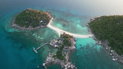 drone over white sand paths and turquoise waters of koh tao’s nang yuan island