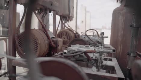 Row-of-Old-Pressure-Washer-Engines-Covered-in-Rust-at-an-Abandoned-Car-Wash-that-was-Destroyed-in-Wildfire---Slow-Motion