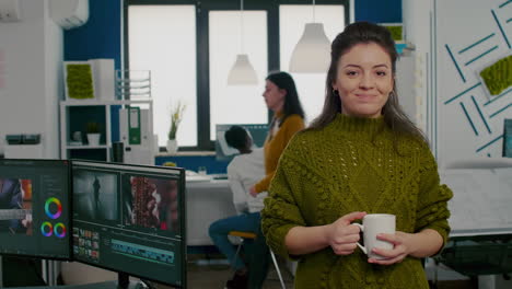 Portrait-of-creative-designer-smiling-at-camera-holding-a-cup-of-coffee