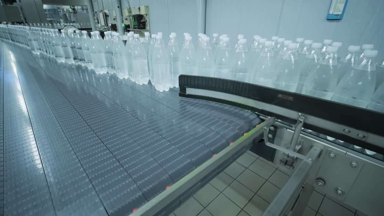 Conveyor belt with bottles of drinking water at a modern beverage plant