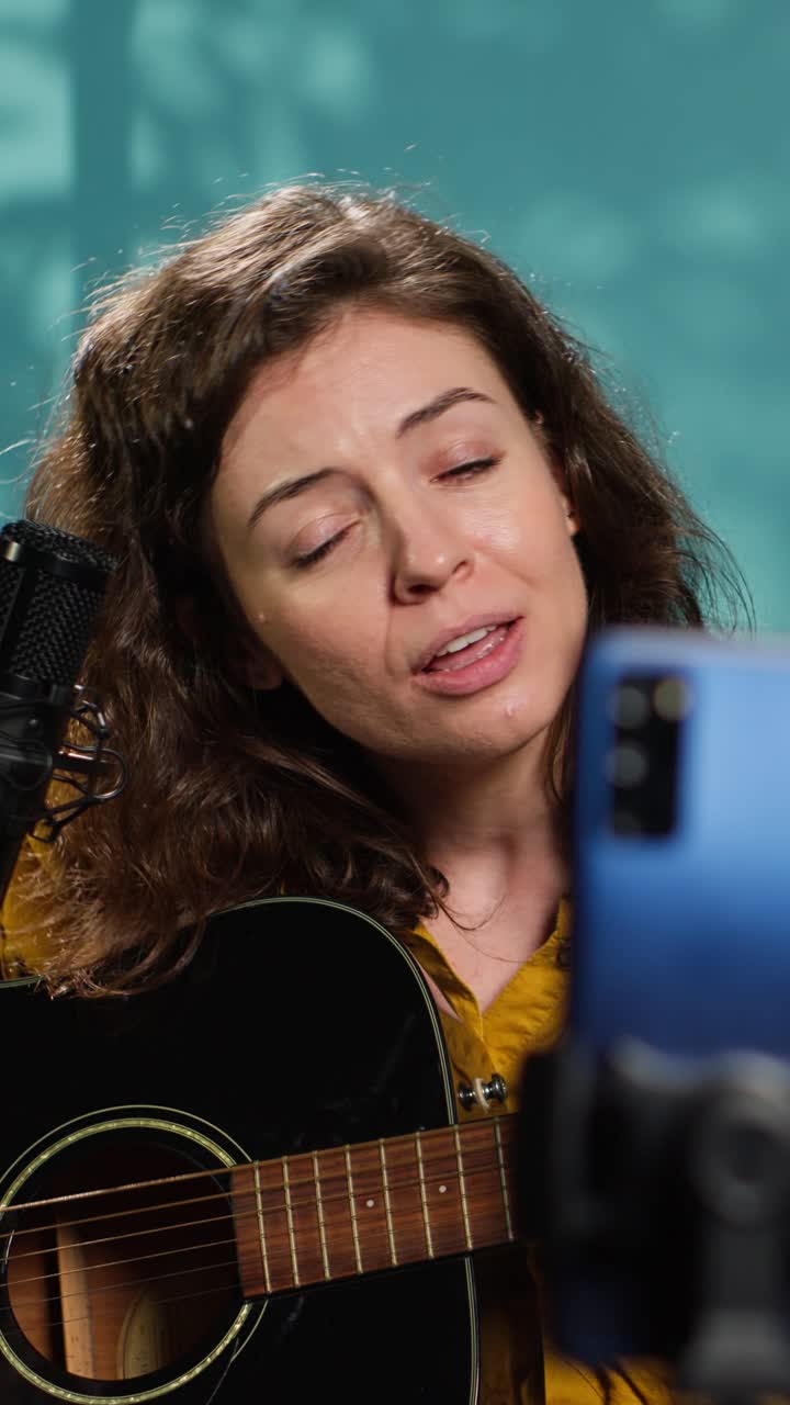 Donna che suona la chitarra acustica e canta al microfono