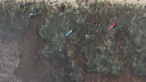 vista aérea, actividades de los turistas de vacaciones en la playa de sadranan, gunung kidul, yogyakarta usando canoas y nadando