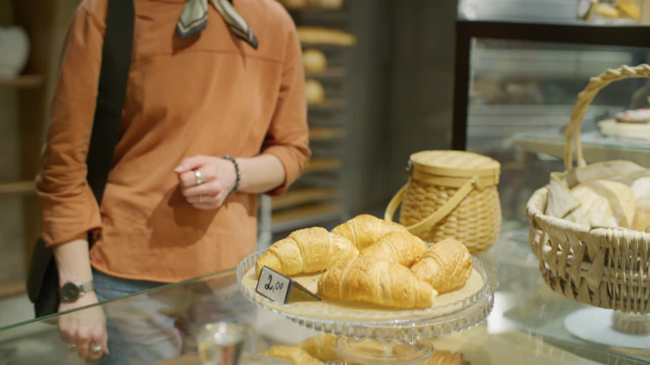 Woman buying croissants in a bakery