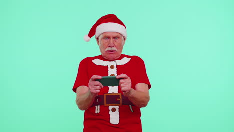 Worried-grandfather-in-Christmas-t-shirt-enthusiastically-playing-racing-video-games-on-mobile-phone