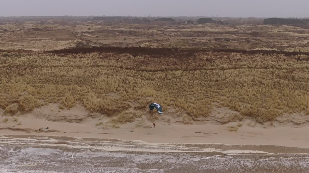 Paragliding over a beach with sand dunes