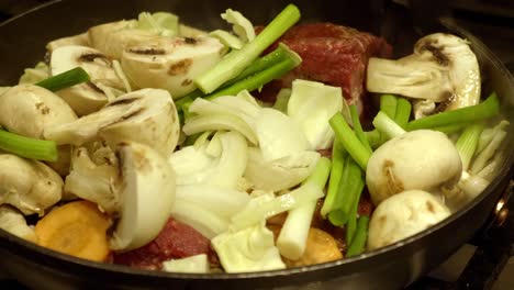 persontossing fresh ingredients of korean stew in a big pot - close up shot