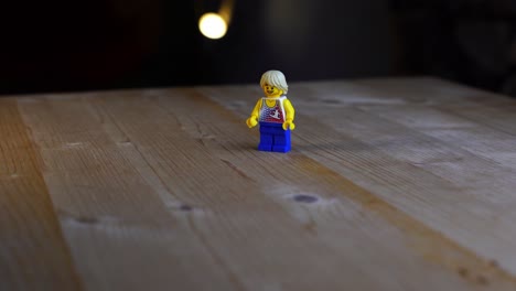 teenage plastic toy figure on a wooden table with dark background