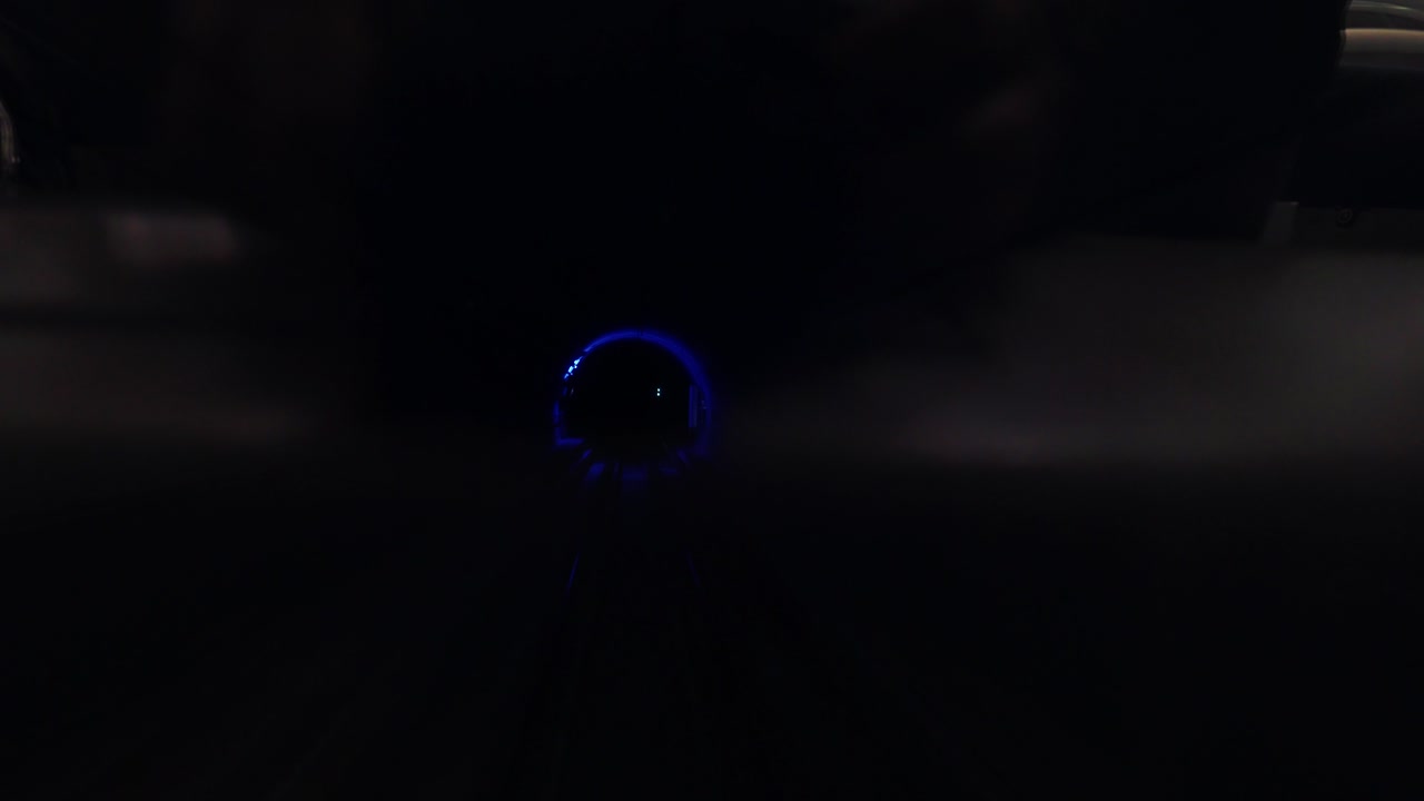 Driving through a dark underground subway tunnel with futuristic blue glow