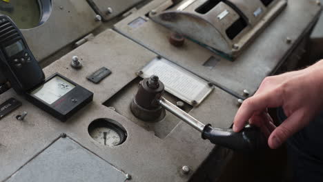 hand operating controls on a vintage ship's bridge console