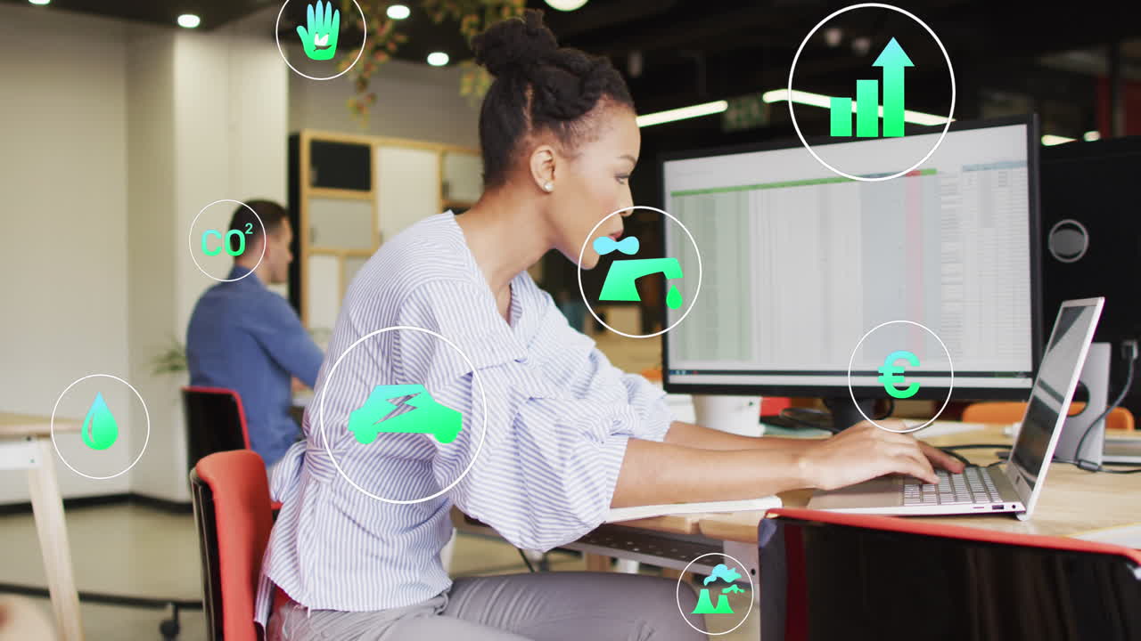 animación de iconos sobre una mujer de negocios afroamericana que usa una computadora portátil en la oficina